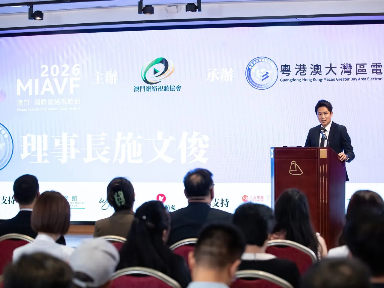 Sean Own delivering the keynote at the Macao Science Centre podium, with 'Charles Si, Deputy Director' displayed on the screen behind him, Macao, 2 June 2026