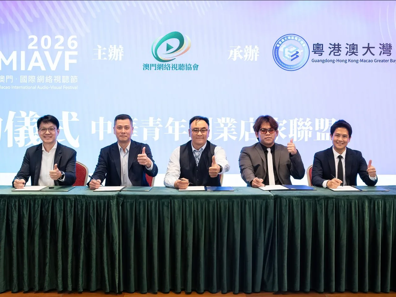 Five partners giving a thumbs-up after signing the Youth Entrepreneur-Merchant Alliance agreement, Macao, 2 June 2026