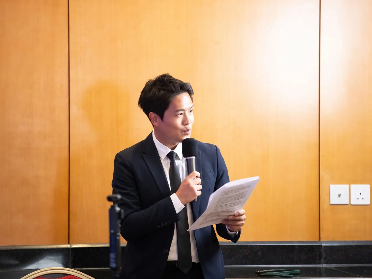 A speaker reading from a paper on stage during the Bay Youth AI forum, Macao, 2 June 2026