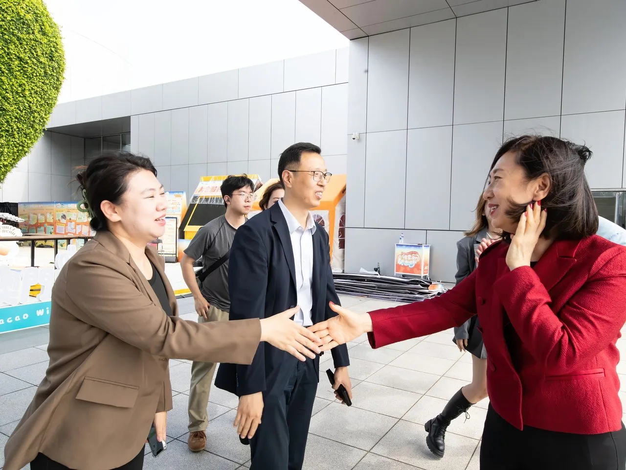 Delegates greeting one another in front of the Macao Science Centre's heart-shaped green wall, 2 June 2026